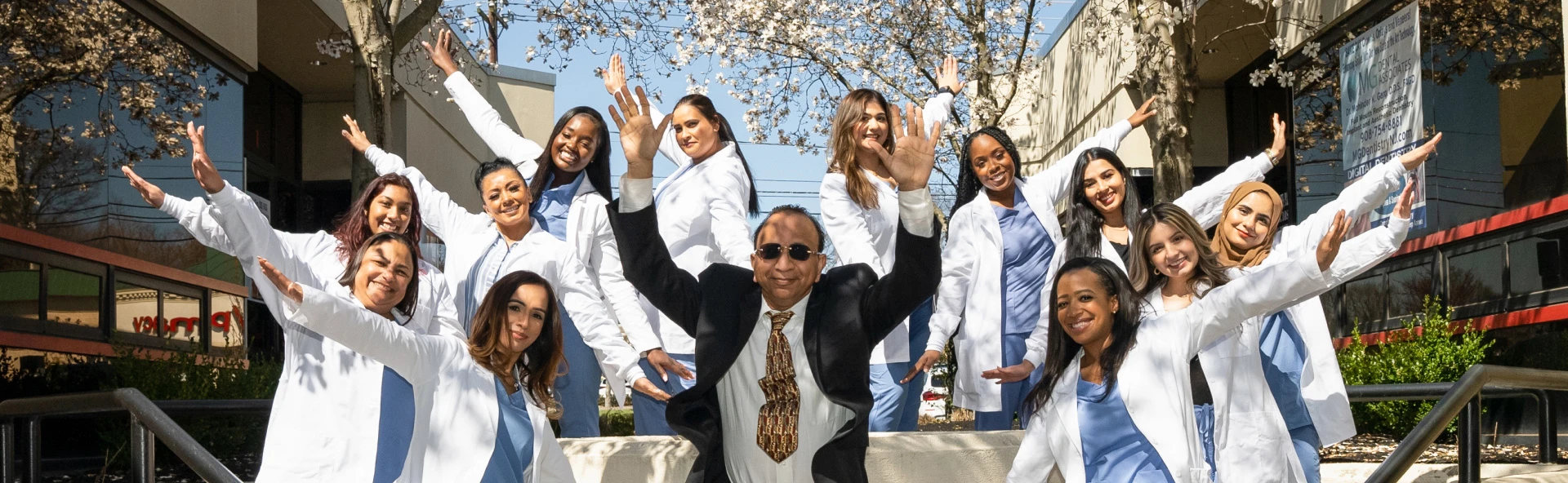 Dr. Mohinder Garg and the MG Dental Associates team waving in front of the South Plainfield office